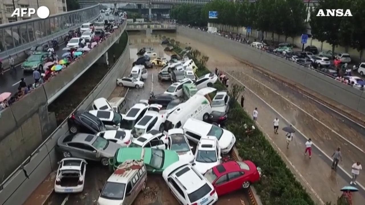 Cina, Zhengzhou dopo l'alluvione: le macchine impilate bloccano l'autostrada sommersa dal fango