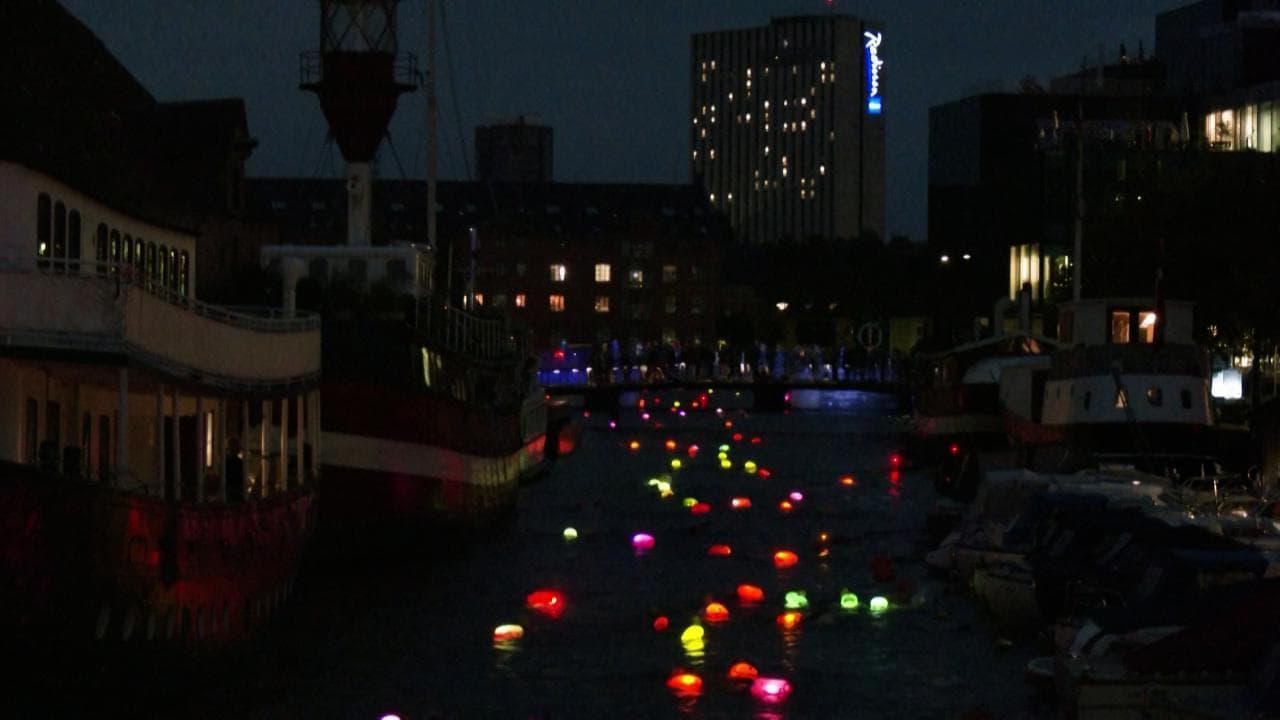 Sembrano lanterne in acqua, ma sono persone: la suggestiva nuotata notturna nel porto di Copenaghen
