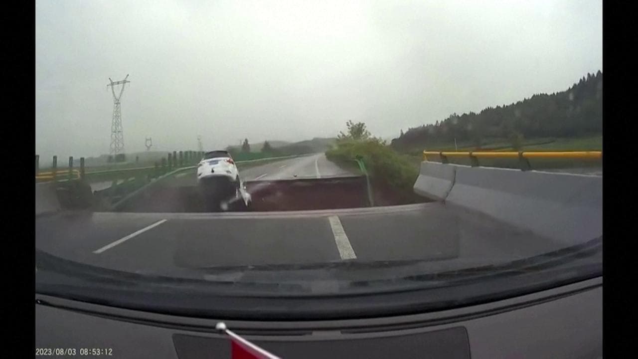 Il ponte collassa per le forti piogge, l'auto scompare nel cratere: le immagini della dashcam
