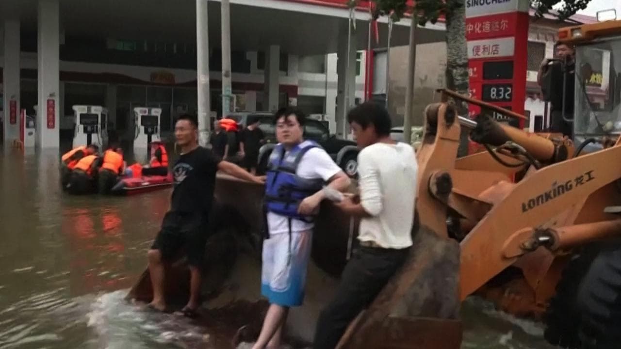 Maltempo, nella Cina inondata dalle piogge la gente viene salvata con una pala meccanica