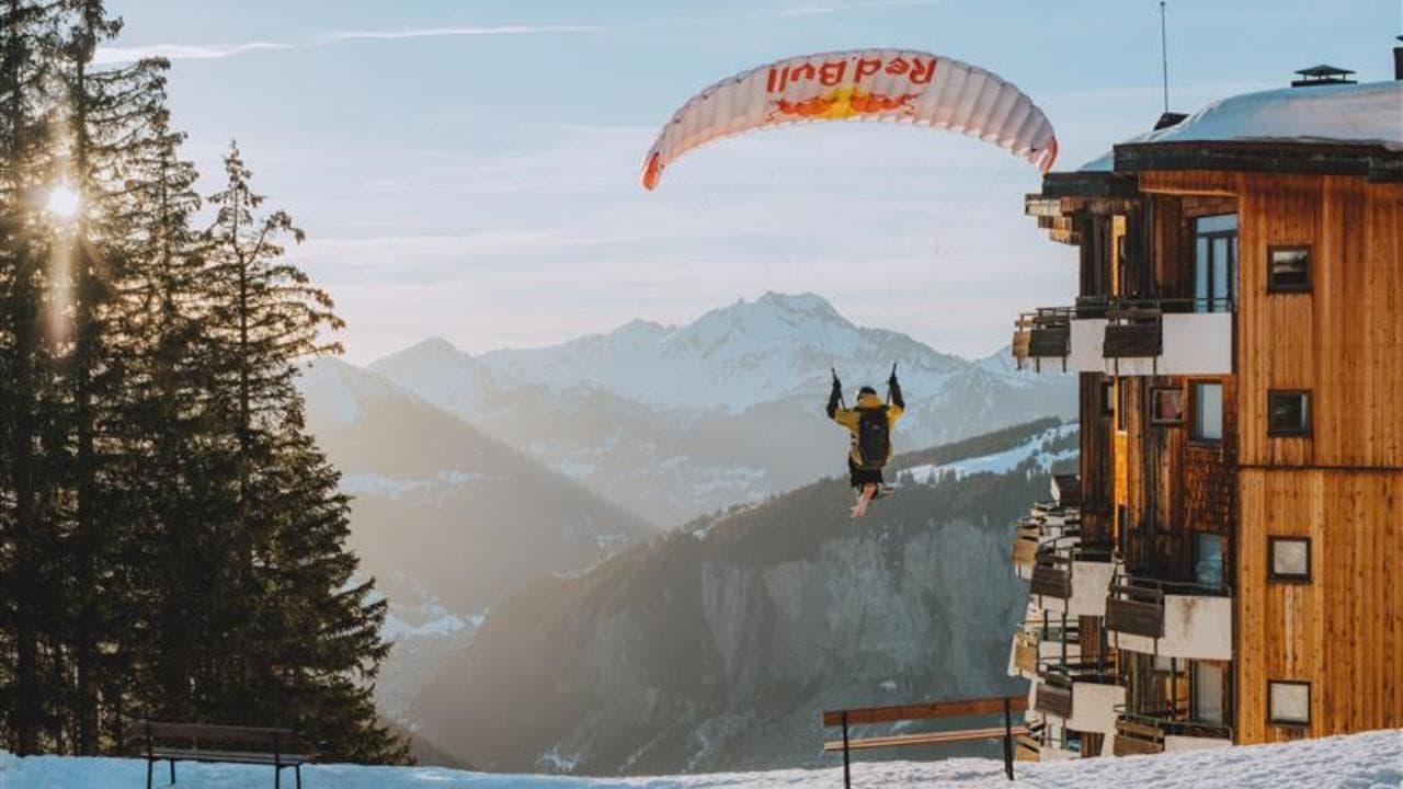 Francia, giù dalle Alpi col parapendio: gli sci sfiorano i palazzi innevati