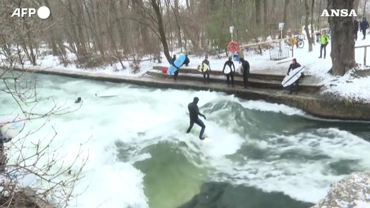 Monaco, con il freddo e la neve i surfisti cavalcano le onde del fiume