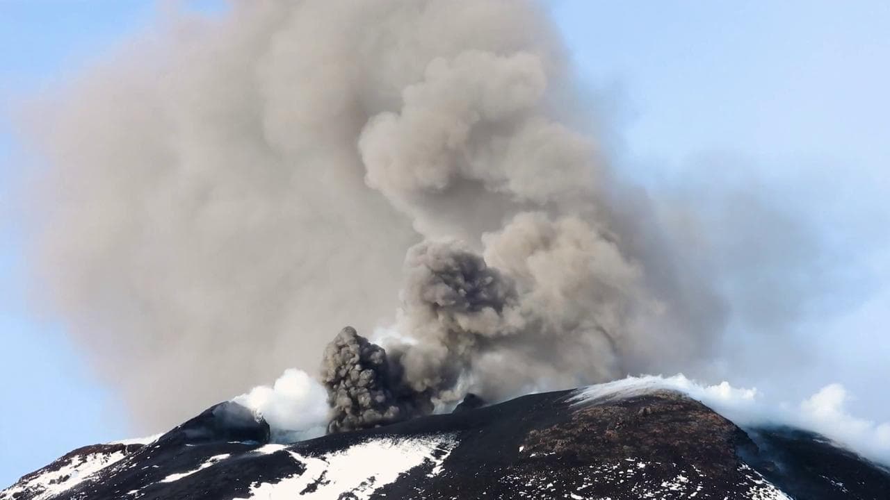 L'Etna dà spettacolo al tramonto: dalla cima innevata si alza un'alta colonna di fumo
