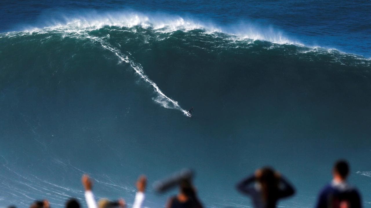 Portogallo, le onde giganti non spaventano i surfisti: acrobazie su muri d'acqua alti oltre 20 metri