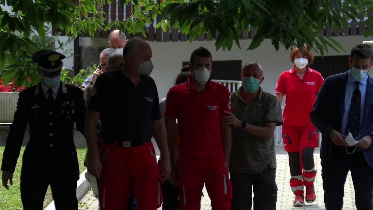 Tragedia di Lecco, sanitari e forze dell'ordine scortano la madre dei gemelli all'uscita dalla casa del duplice delitto