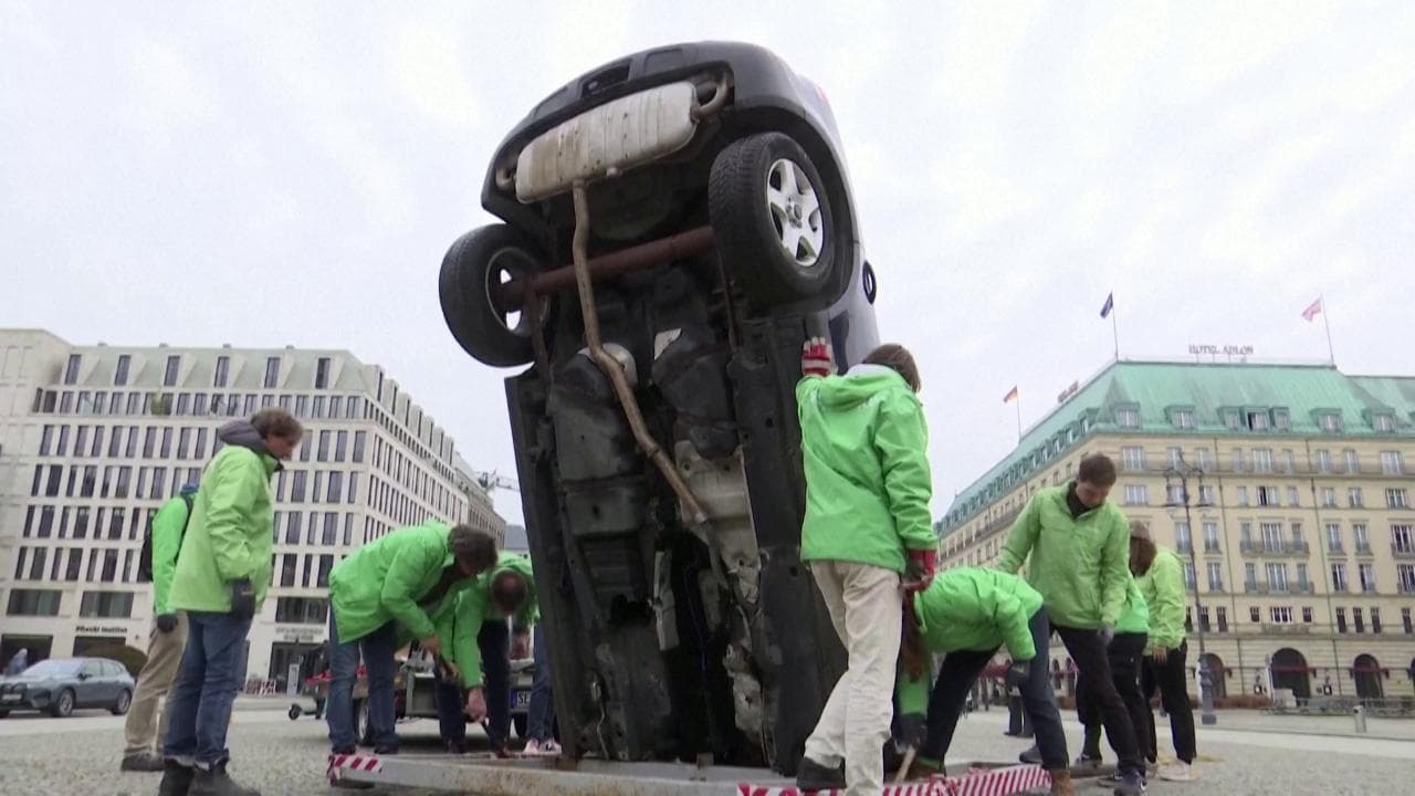 Un'auto schiantata sul manto stradale, così Greenpeace protesta a Berlino