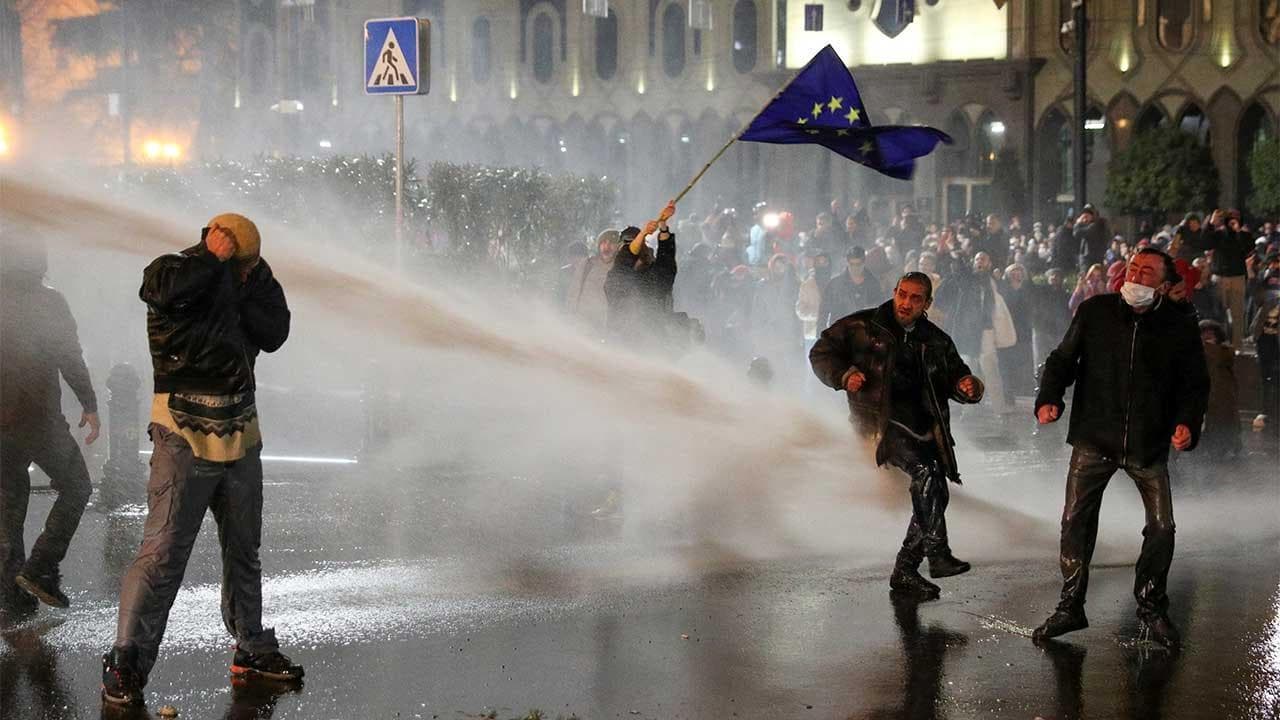 Georgia, proteste contro il governo filorusso: la donna sventola bandiera Ue e resiste agli idranti