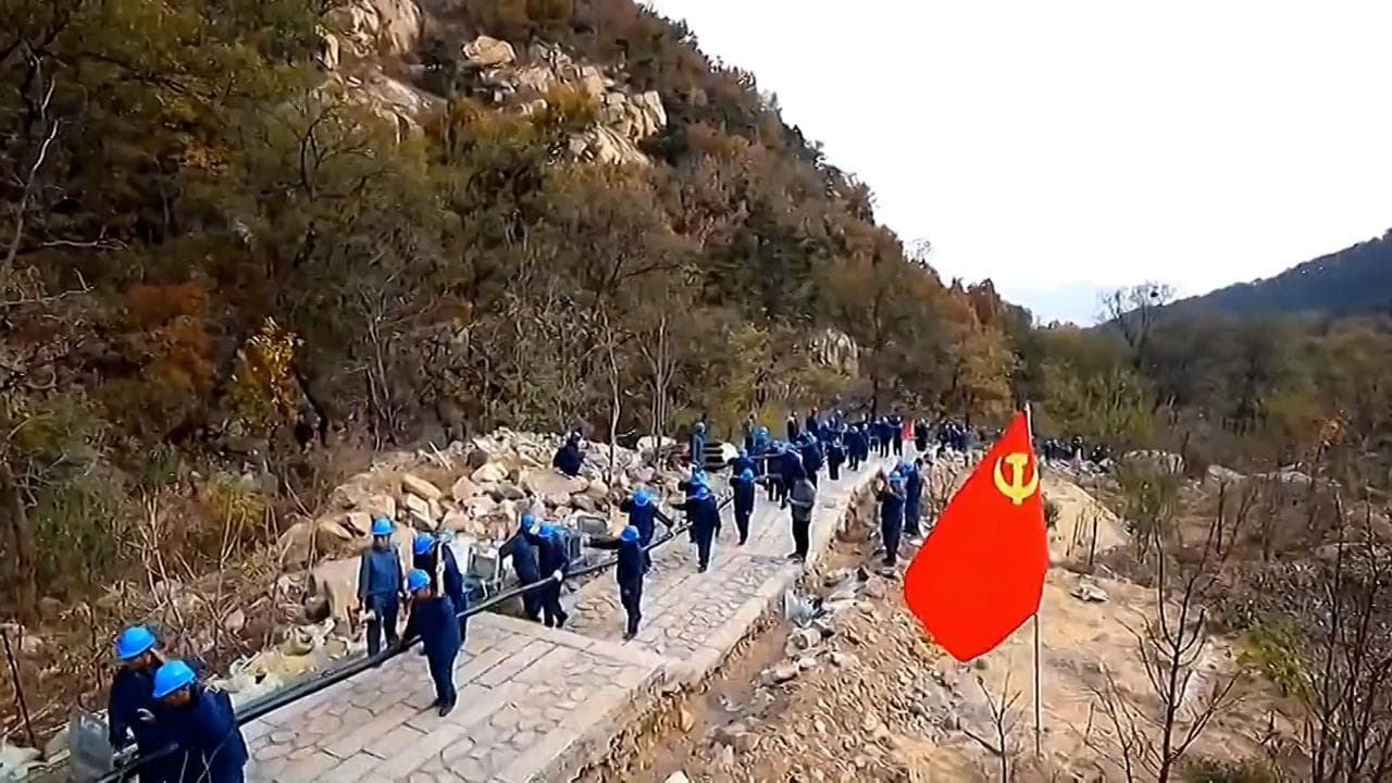 Cina, la lunga marcia degli operai: centinaia portano cavi per la centrale elettrica sul Monte Tai