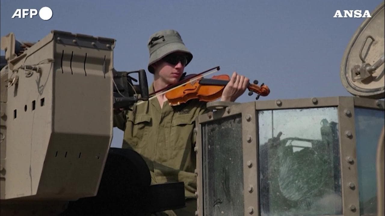 Un soldato dell'Idf suona il violino su un carro armato al confine con Gaza