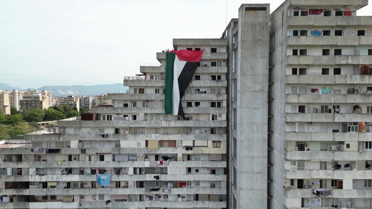 Una bandiera palestinese alta cinque piani sventola sulla Vela Celeste di Scampia: "Gaza non è sola"