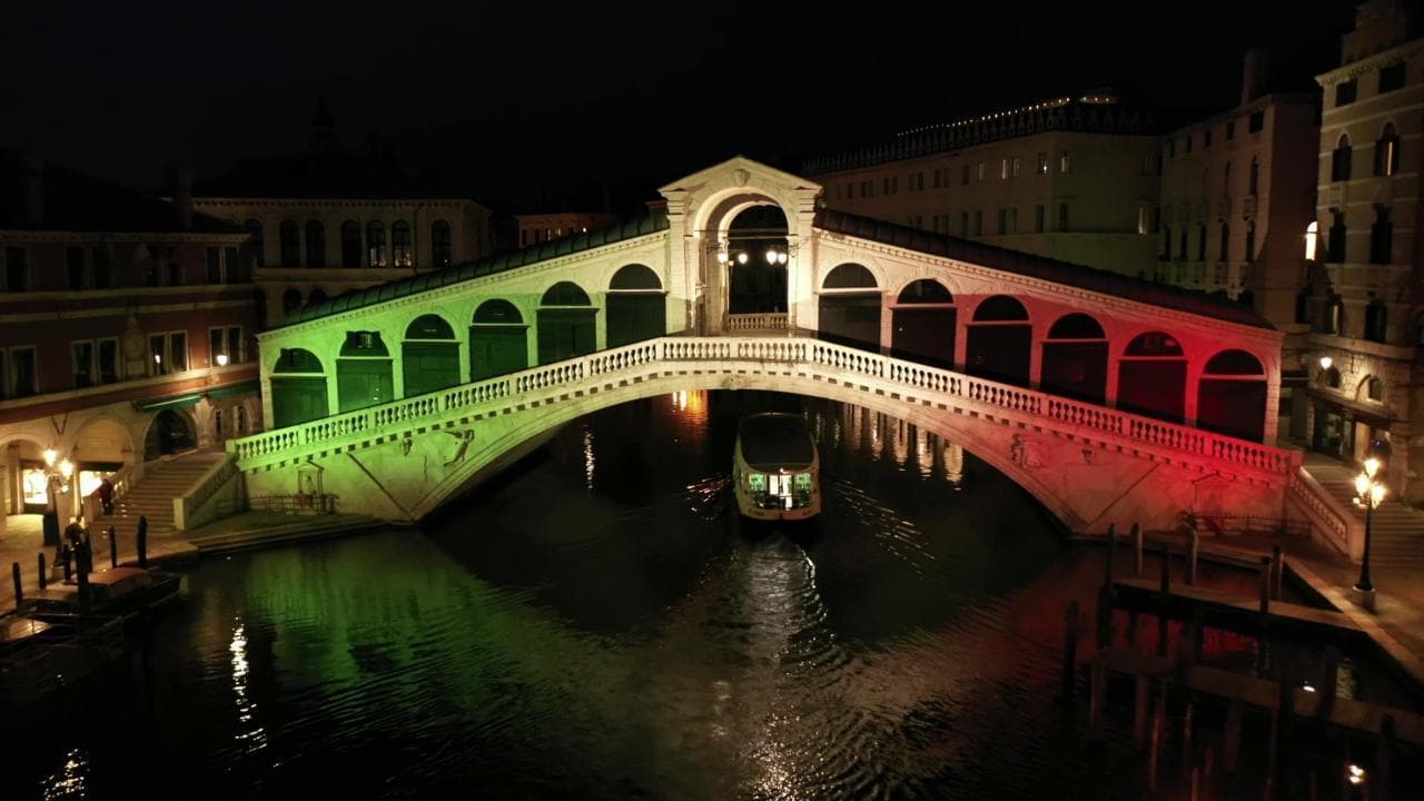 Coronavirus, il ponte di Rialto tricolore illumina la notte di Venezia: le immagini dal drone