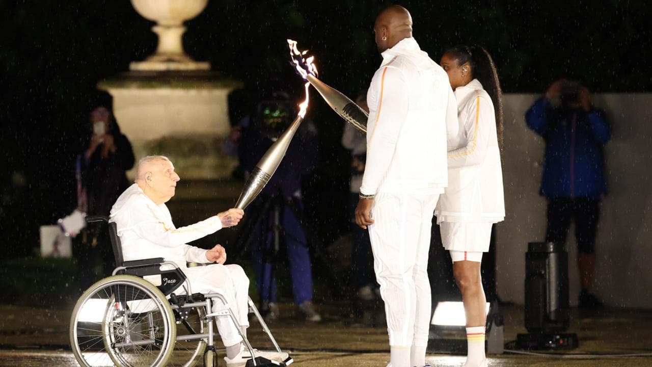 Marie-Jose Perec e Teddy Riner ricevon o la fiaccola dal centenario campione olimpico Charles Coste