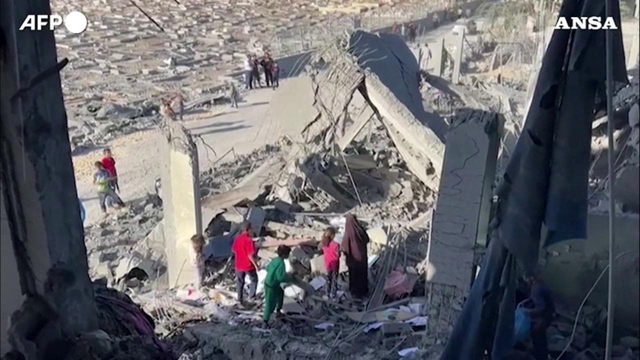 Gli abitanti di Rafah cercano di recuperare coperte e altri oggetti dopo un bombardamento israeliano