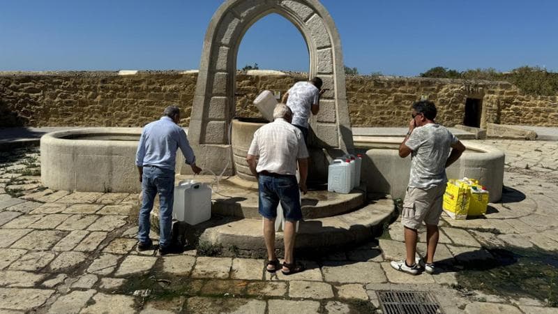 Un gruppo di persone fanno la fila per riempire le taniche davanti alla fontana Bonamorone di Agrigento (Riccardo Staglianò)