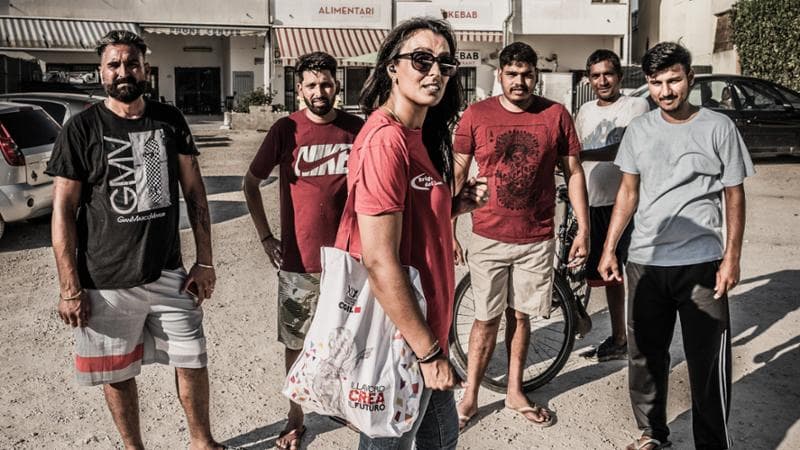 Laura Hardeep Kaur (37 anni), fotografata nel villaggio di Bella Farnia, vicino a Sabaudia (Latina), con un gruppo di lavoratori indiani (Luigi Narici/Agf)