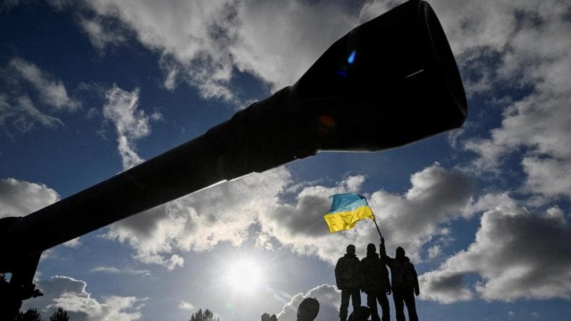 Un soldato ucraino sventola la bandiera dietro al cannone di un Challenger 2 fornito da Londra