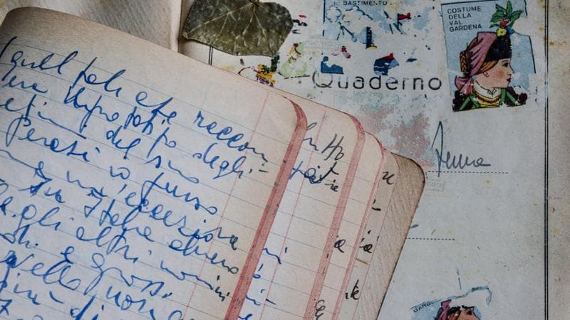 Alcuni quaderni raccolti nell’Archivio, pagine e video su una parete del Piccolo Museo.