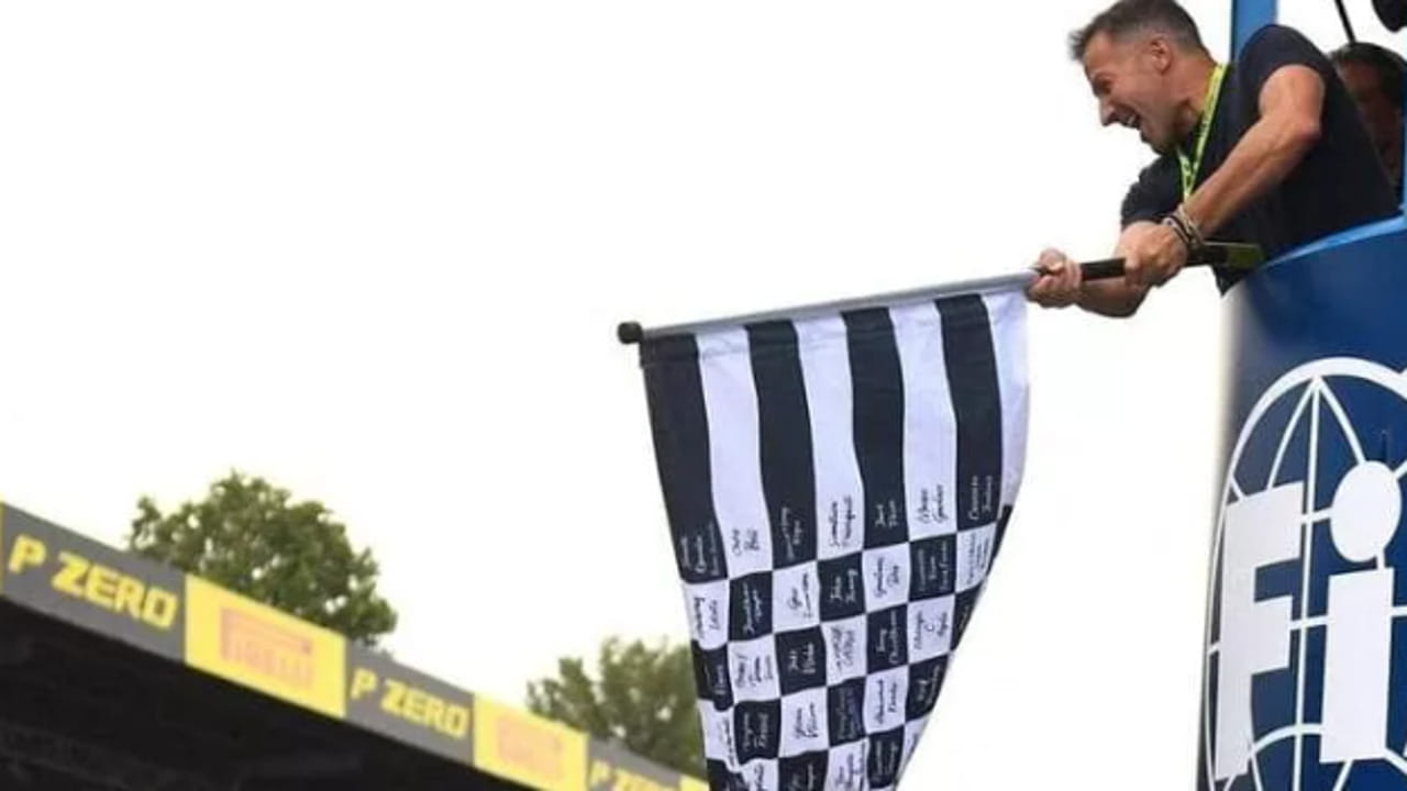 Trionfo Ferrari a Monza: Del Piero esulta e sventola la bandiera a scacchi al passaggio di Leclerc