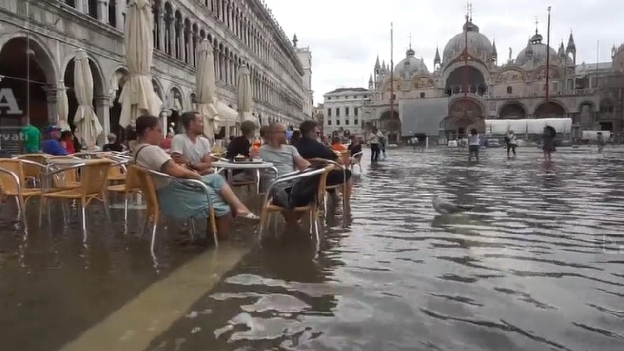 L'acqua alta a Venezia non scoraggia i turisti: aperitivo in piazza San Marco con i piedi a mollo