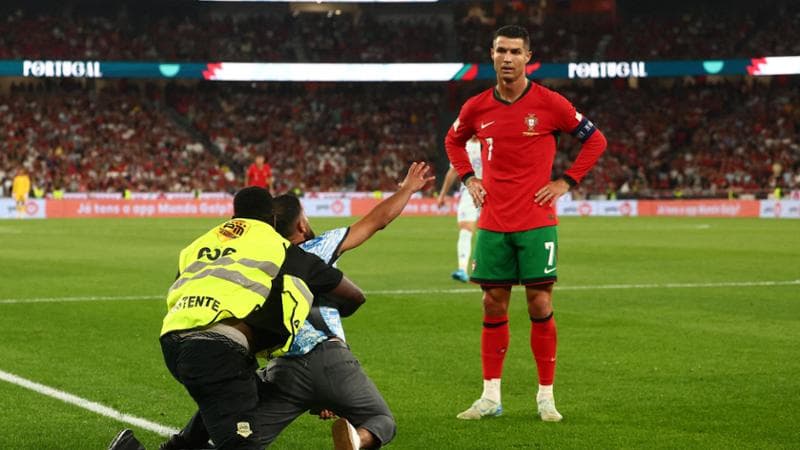 Un invasore di campo bloccato mentre si inginocchia di fronte a Ronaldo