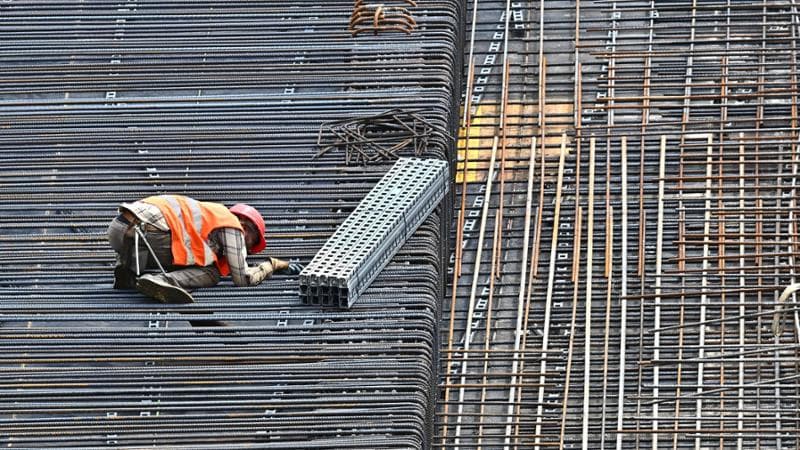 Un operaio edile si disseta bevendo acqua al lavoro sotto il sole in un cantiere&nbsp;
