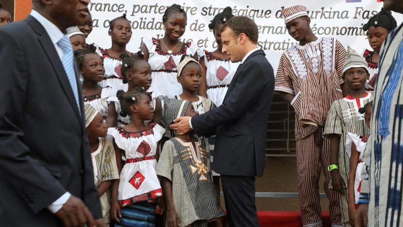 Il presidente francese, Emmanuel Macron, mentre incontra gli alunni di una scuola di Ouagadougou, capitale del Burkina Faso (Getty images)