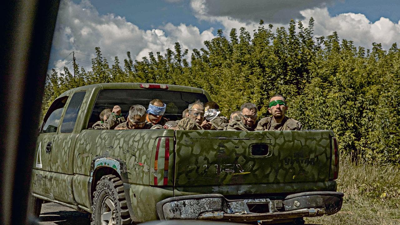 A Ukrainian military vehicle drives from the direction of the border with Russia carrying blindfolded men in Russian military uniforms, in the Sumy region, on August 13, 2024, amid the Russian invasion of Ukraine. On August 6, 2024, Ukraine launched an offensive surprise into the Russian border region of Kursk capturing over two dozen towns and villages in the most significant cross-border attack on Russian territory since World War II. Ukraine's military chief Oleksandr Syrsky told the Ukrainian President in a video posted on August 12, 2024 that his troops now control about 1,000 square kilometres of Russian territory and are continuing "offensive operations". (Photo by Roman PILIPEY / AFP)