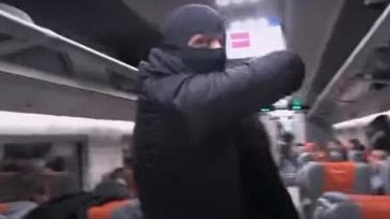 Il finto terrorista con passamontagna minaccia i passeggeri