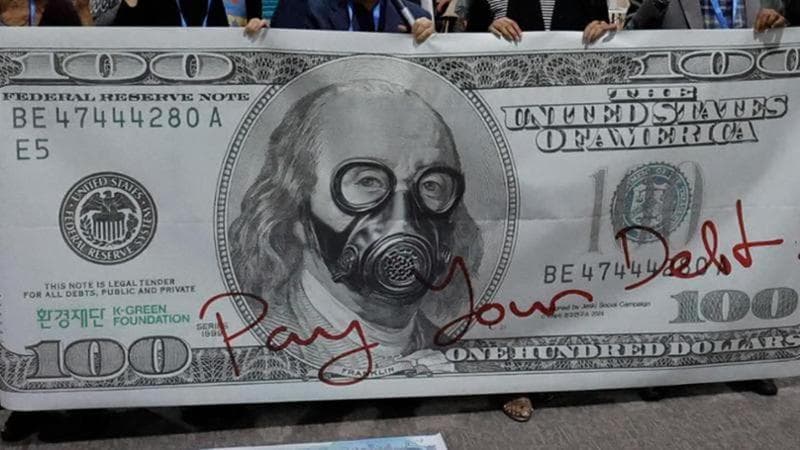 "Pagate il vostro debito" in un cartellone di protesta a Baku