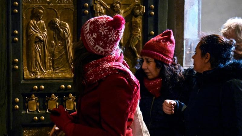 Città del Vaticano, 25 dicembre: pellegrini attraversano la porta santa nella basilica di San Pietro