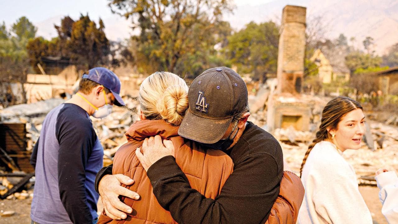 Aaron Lubeley (2nd R) hugs a family member and cries while viewing the burned remains of his home during the Eaton fire in the Altadena area of Los Angeles county, California on January 9, 2025. Wildfires threatened to engulf parts of Hollywood on January 9 as a growing number of blazes raged across Los Angeles, forcing over 100,000 people to flee their homes and claiming at least five lives. (Photo by JOSH EDELSON / AFP)