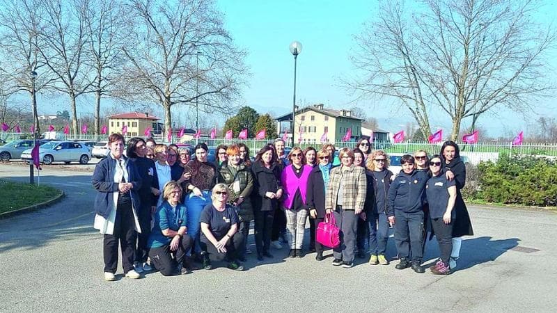 Un gruppo di operai davanti ai cancelli dell'azienda