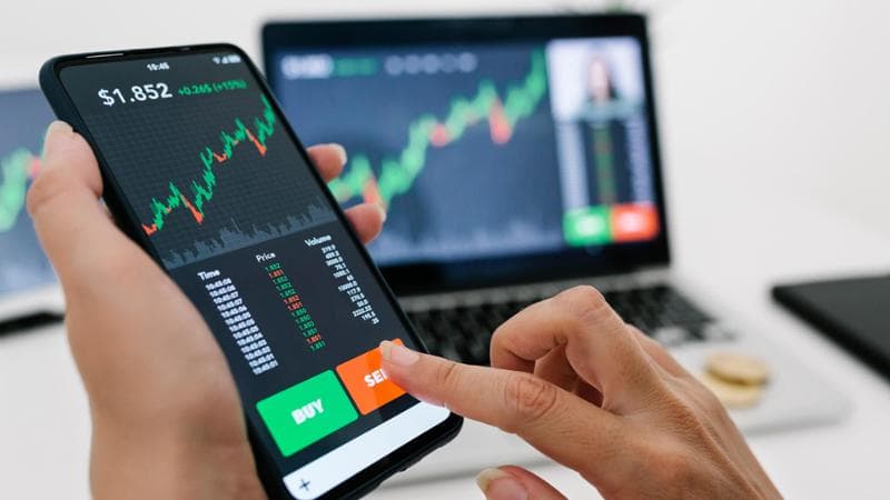 Female manager selling cryptocurrencies through mobile phone app. Stock market, investment and cryptocurrencies concept