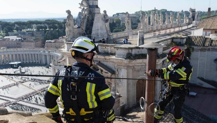 L'installazione sul tetto della Cappella Sistina del comignolo dal quale uscirà la fumata