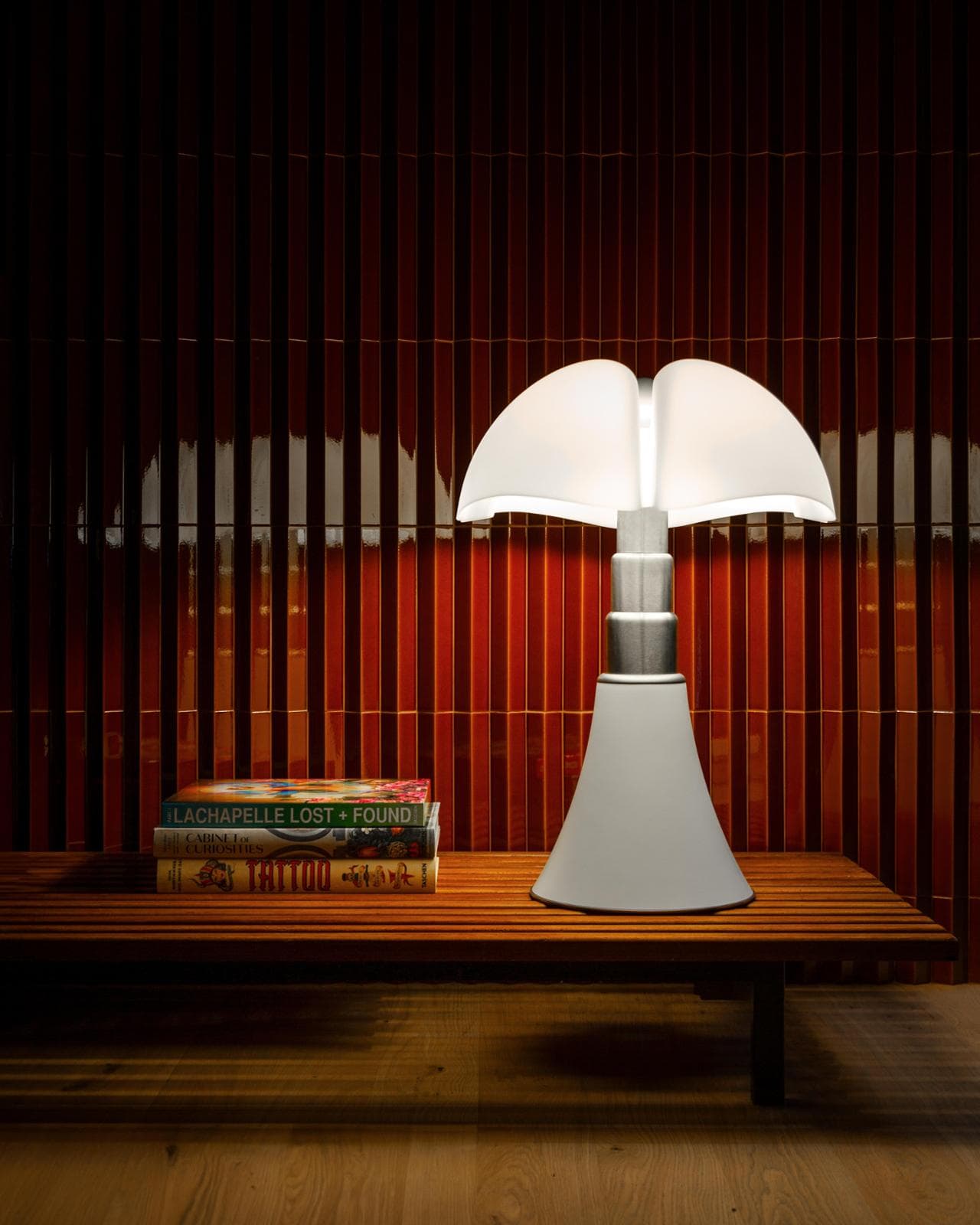 Martinelli Luce veste di bianco matt la lampada Pipistrello di Gae Aulenti e la arricchisce con l’incisione “60 anni” e un piccolo cristallo Swarovski incastonato (foto Diego Laurino)