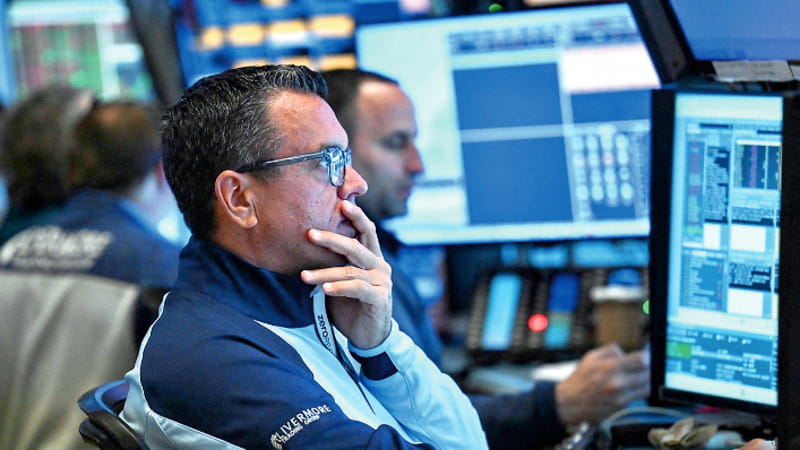 Operatori davanti agli schermi di Borsa