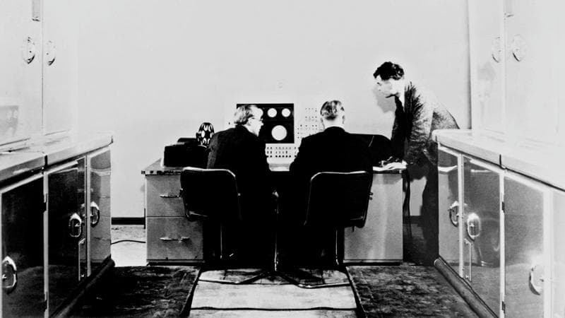 Alan Turing,&nbsp;a destra, al lavoro&nbsp;al computer Ferranti&nbsp;Mark 1 con dei colleghi
