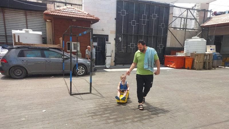 Il piccolo Carlos gioca con la sua macchinina a pedali nel cortile della parrocchia della Sacra famiglia di Gaza