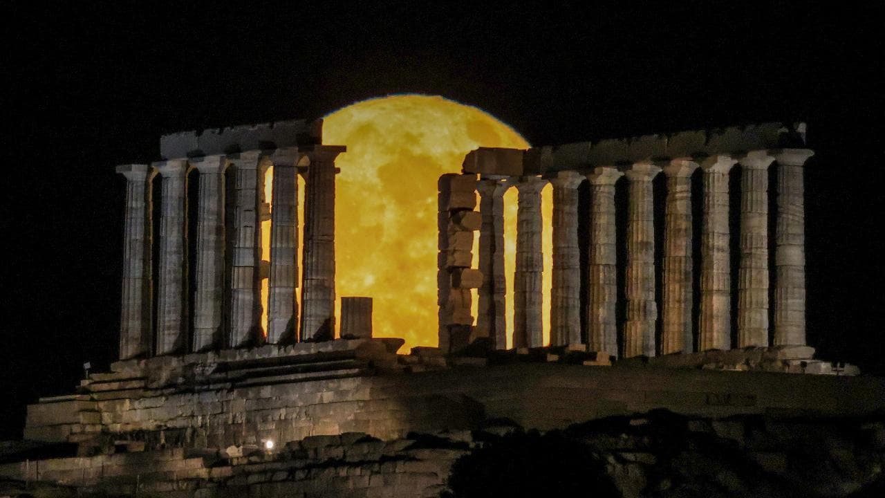 Lo spettacolo della luna piena "delle fragole" mentre sorge dietro il tempio di Poseidone in Grecia