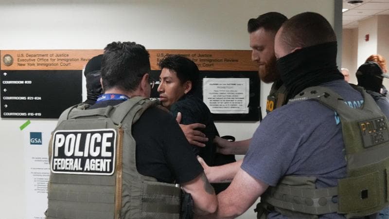 An unidentified immigrant is detained by US Immigration and Customs Enforcement (ICE) agents inside the Federal Plaza courthouse following his legal proceedings on June 27, 2025 in New York. In recent weeks, there has been an uptick of immigration enforcement operations at courthouses, as thousands of migrants pursue the asylum process by attending hearings. Agents from US Immigration and Customs Enforcement (ICE) enter the court facilities unidentified, migrant advocates say, and those who do wear badges often cover their faces. Since President Donald Trump returned to power in January, ICE has been authorized to conduct enforcement activities in courts. (Photo by Bryan R. SMITH / AFP)