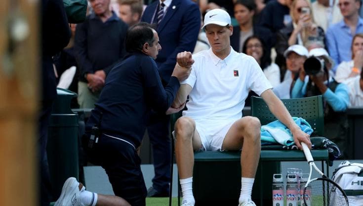 Jannik Sinner assistito dal medico durante il match con Dimitrov