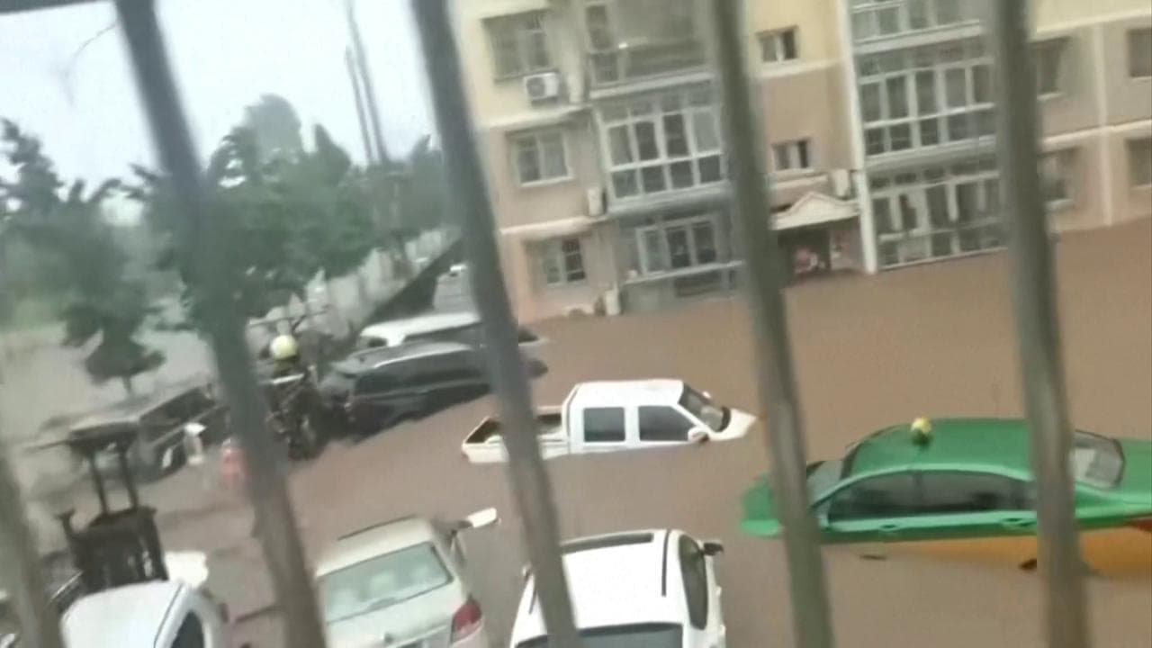 Pechino, fiumi d'acqua per le piogge intense trascinano le automobili in strada