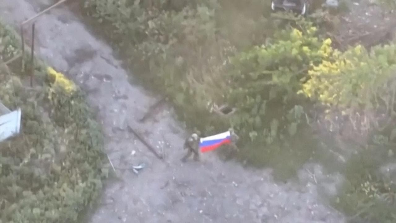 Soldati russi sventolano la bandiera nazionale nel paese di Yablunivka, in Ucraina