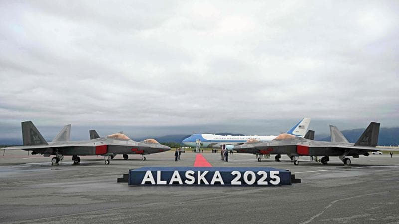 I caccia F-22 sulla pista di Anchorage. Sullo sfondo, l&rsquo;Air Force One del presidente Trump
