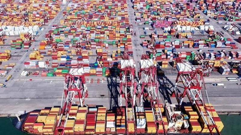 G ru che caricano i container nel porto cinese di Qingdao (AFP)