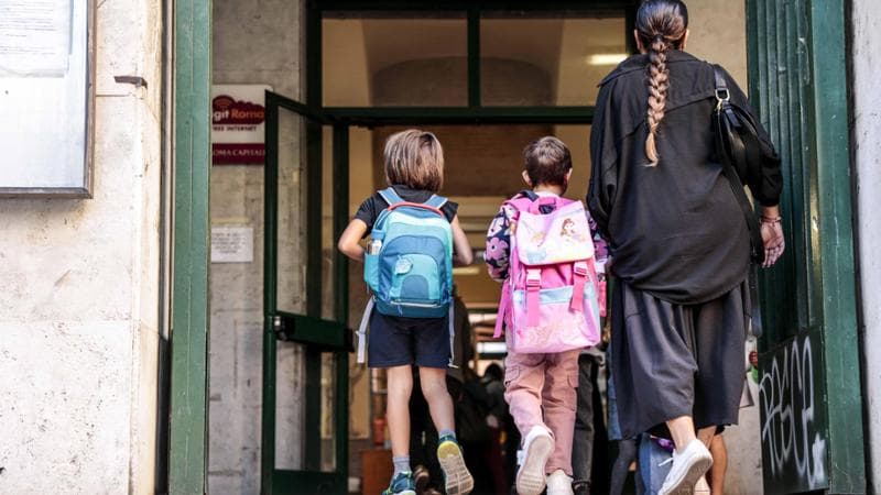 Piccoli studenti di una primaria di Roma accompagnati in aula al loro primo giorno di scuola. Agf