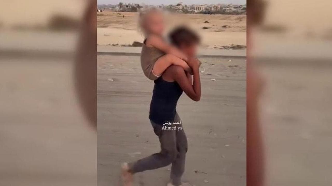 Scalzo tra le macerie: il bambino che porta sulle spalle la sorellina in fuga da Gaza