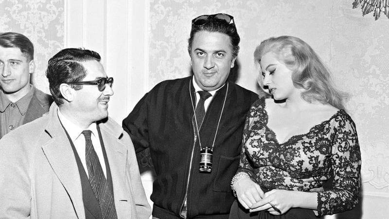 Ennio Flaiano, Anita Ekberg e&nbsp;Federico Fellini (al centro) durante una pausa delle riprese della Dolce vita (1959)
