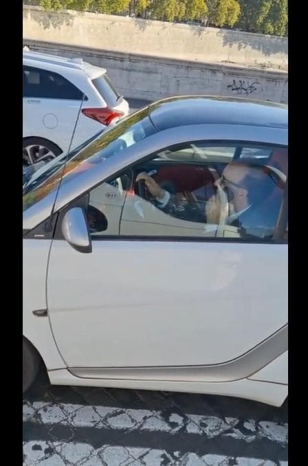 Benigni in auto, mentre parla al cellulare e guida senza cintura di sicurezza