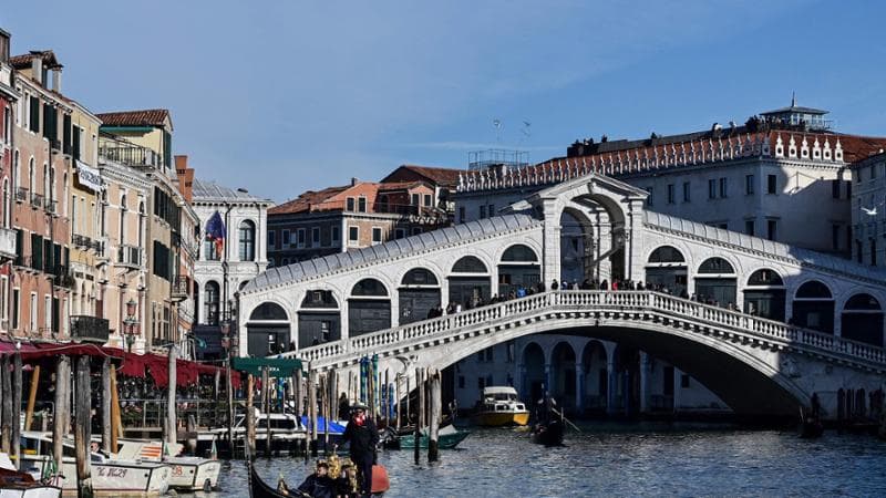A gondolier rows tourists in the Canal Grande, close to Rialto bridge in Venice on December 12, 2021. (Photo by MIGUEL MEDINA / AFP)